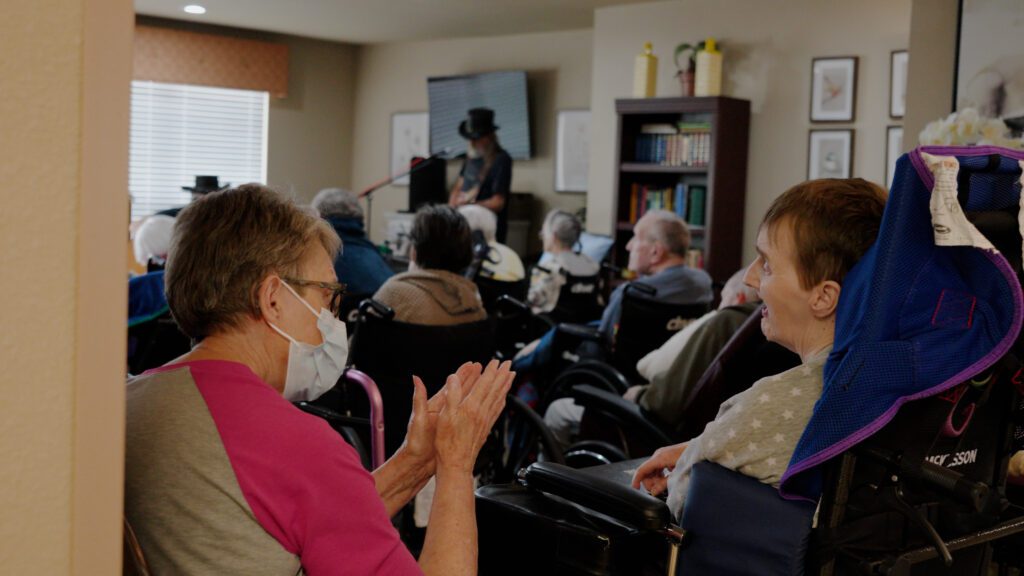 A group of people enjoy music at a skilled nursing facility